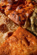 Zeena Bakery focaccia, four different styles (clockwise from top: tomato and onion, zaatar, dukkah, sesame and honey), close up